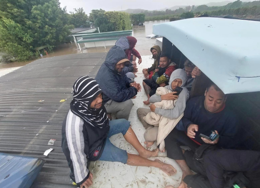 Tongan RSE workers sitting under make shift shelter on the roof of their accommodation waiting for help. Photo Credit: Lie Tu'imoala