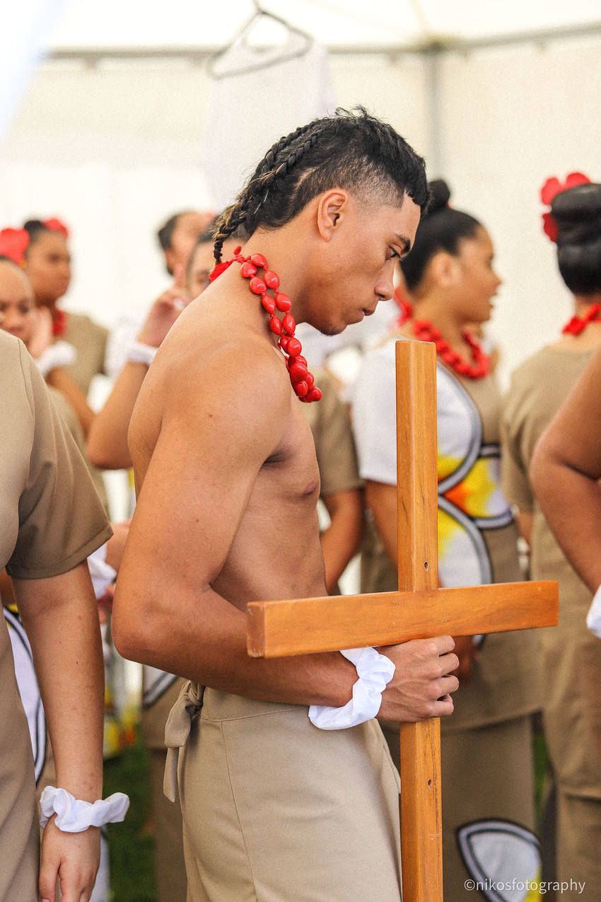 Senior leader Emanuel Tereva holds the wooden cross during backstage prayers. Photo Credit: Frank Talo / Nikos Fotography