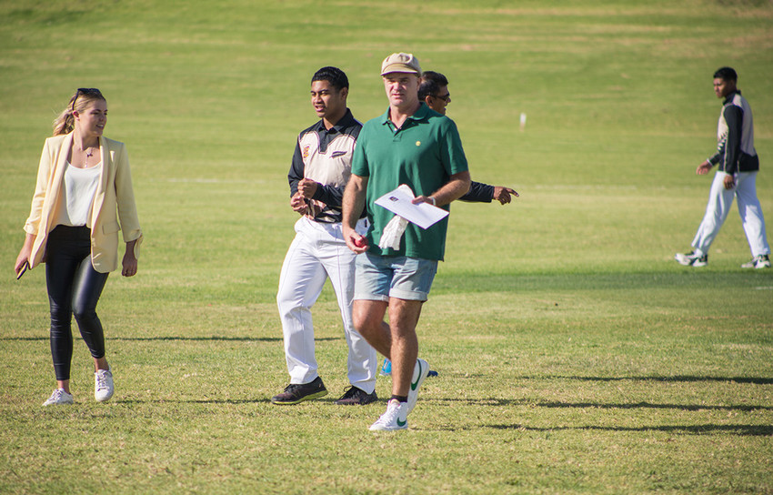Coach Dion Nash walks over the cricket pitch with captain Daniel Smith