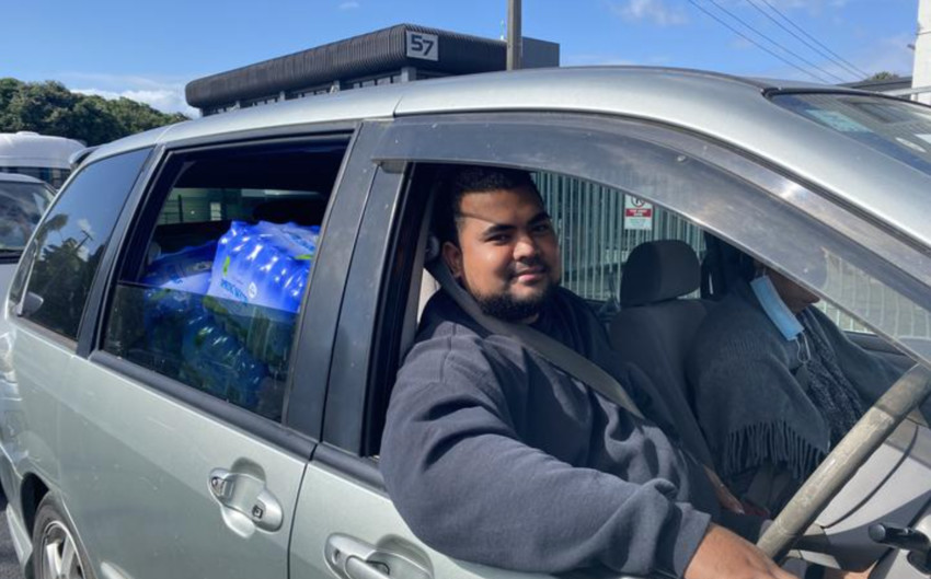 People arrive with bottled water and other goods to send to Tonga. Photo: RNZ / Lydia Lewis