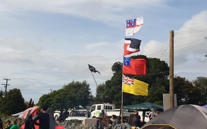 There are a range of flags on show, including (from top to bottom) the United Tribes of New Zealand flag, the tino rangatiratanga flag, the Samoan flag and the Nuienan flag, to represent the unity of all nations. Photo: RNZ / Meriana Johnsen
