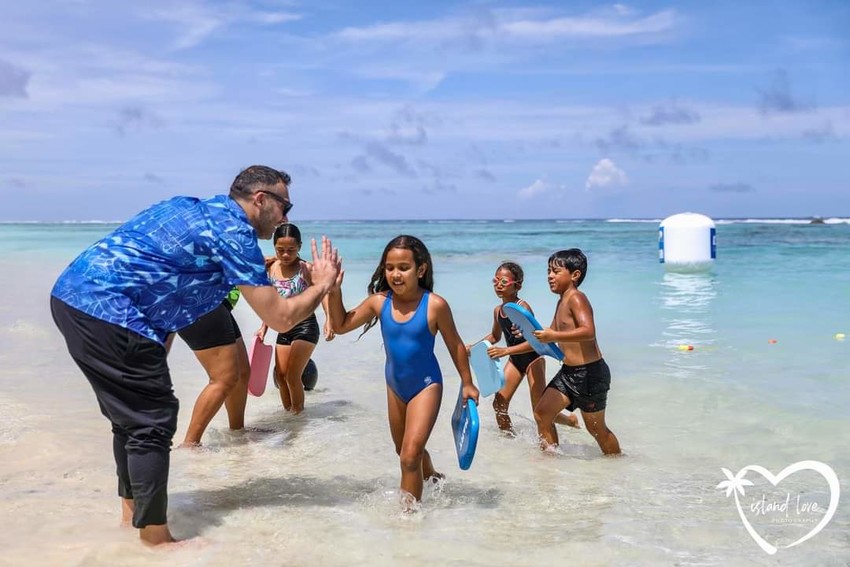 Ian Hi Fives a young swimmer Photo Credit: Island Love Photography