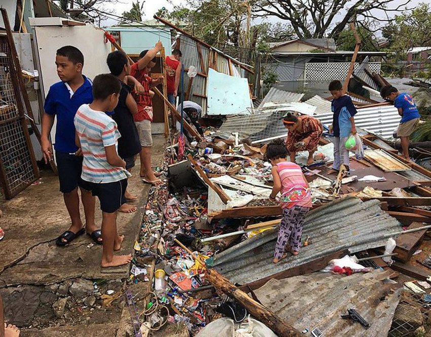 Children picking through roofing in Tonga