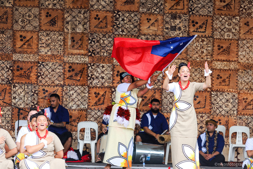 Angelina Finauvala proudly waves the Samoan flag while Jazmin Ugapo leads the National anthem - representing Samoa’s Independence in 1962. Photo Credit: Frank Talo / NikosFotography