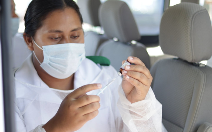 Samoan nurse wearing a mask when administering the measles vaccine